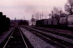 Its getting dark as a northbound train heads for the signals at the north end of the yard